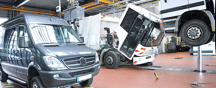 Auto und Lkw auf einer Hebebühne in einer Werkstatt