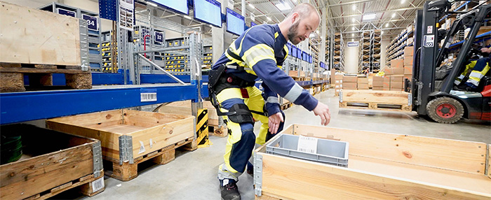 Ein Arbeiter mit Exoskelett in einem Lager